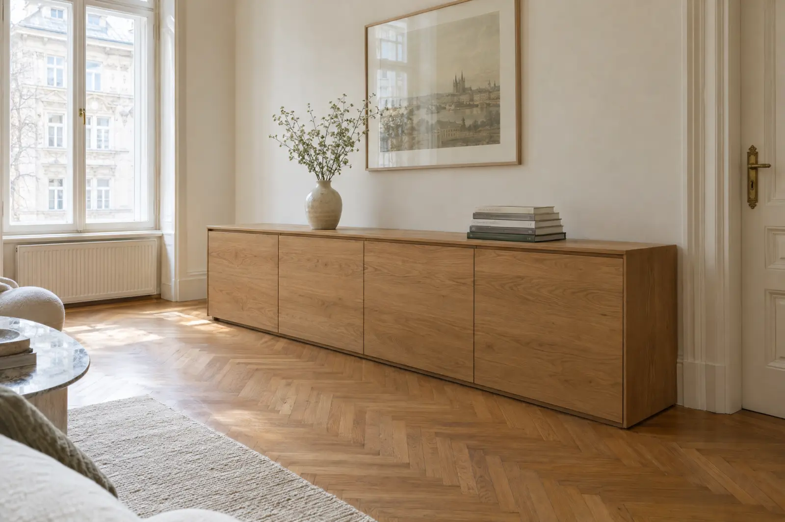 Langes Sideboard aus geölter Eiche an der Wand eines Altbauwohnzimmers mit Fischgrätparkett